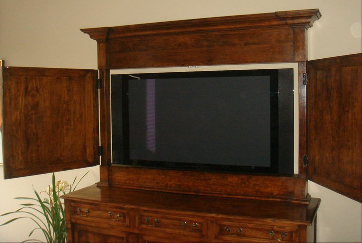 Custom-built cabinet in cherry to hide flat-screen TV with hand-wax finish to match bottom cabinet.
